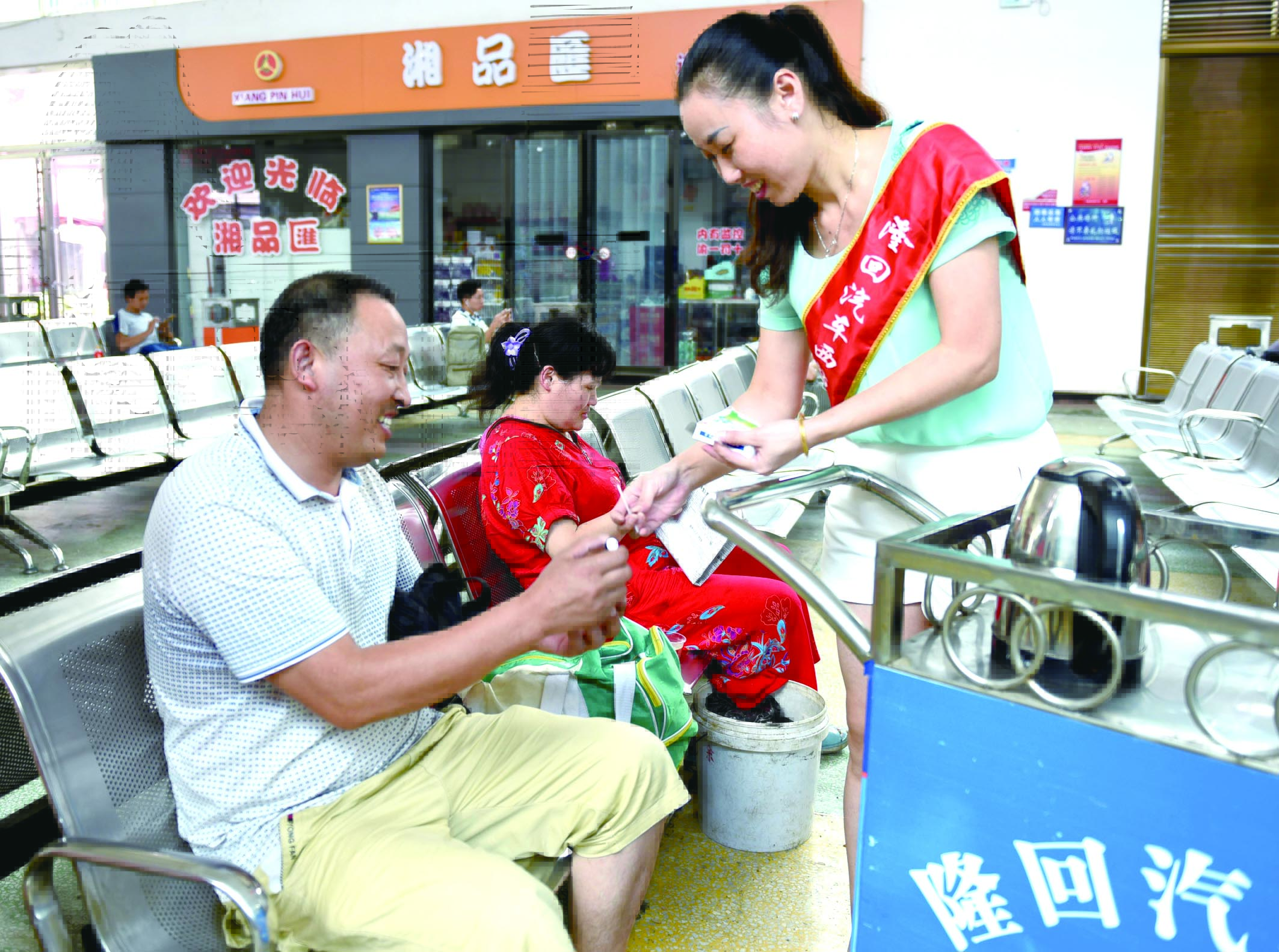 隆回分公司汽車(chē)西站工作人員正在為旅客免費(fèi)贈(zèng)送藿香正氣水。